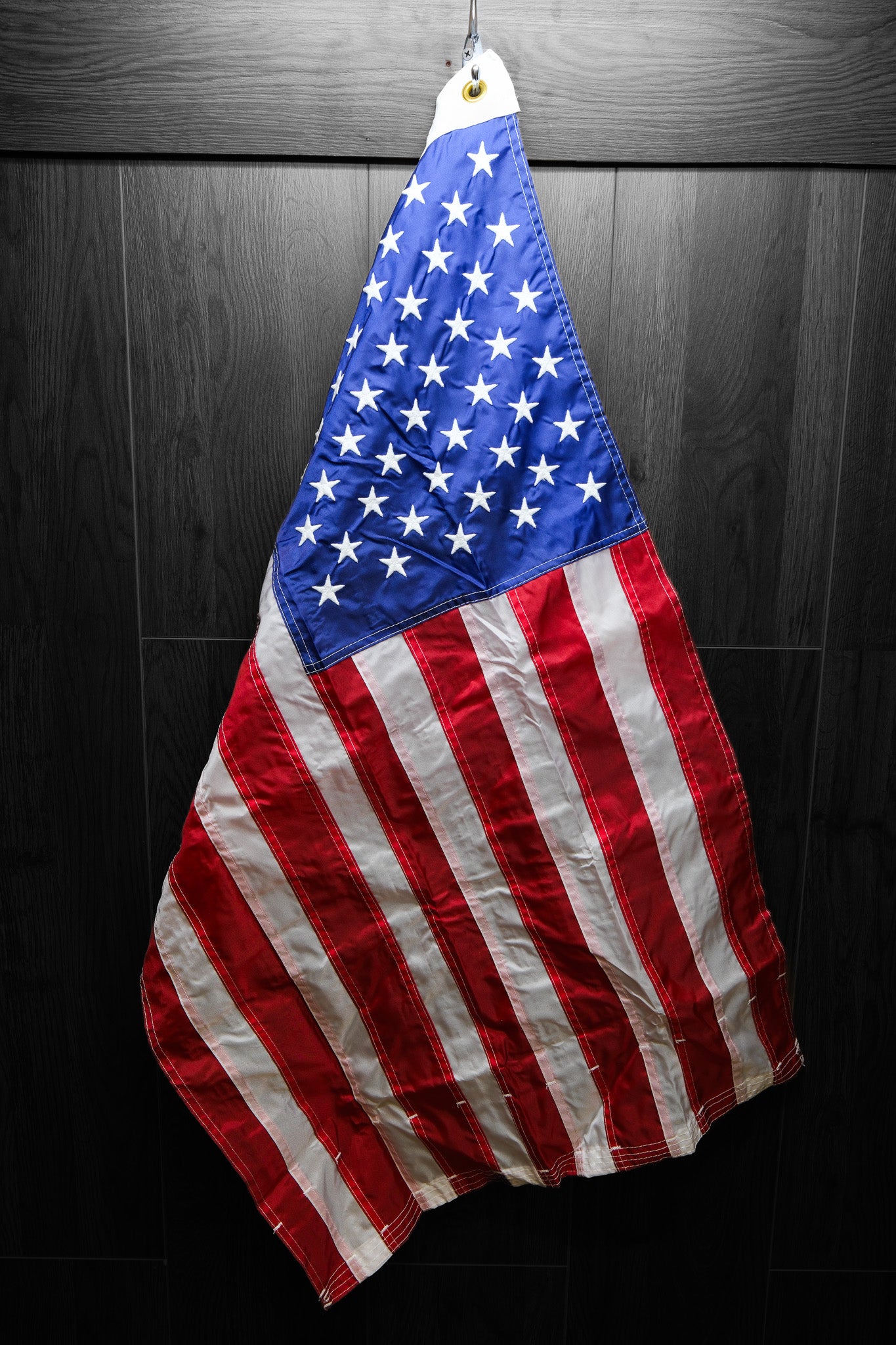 american flag, hanging on a dark background