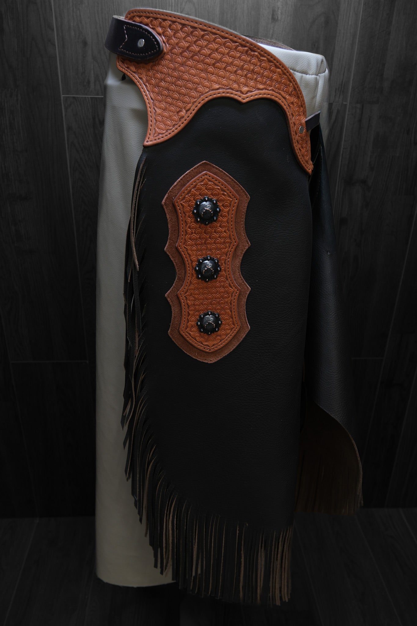 Brown leather chinks with decorative accents and conchos