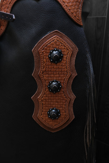 Close up of decorative leather and conchos on a set of chinks