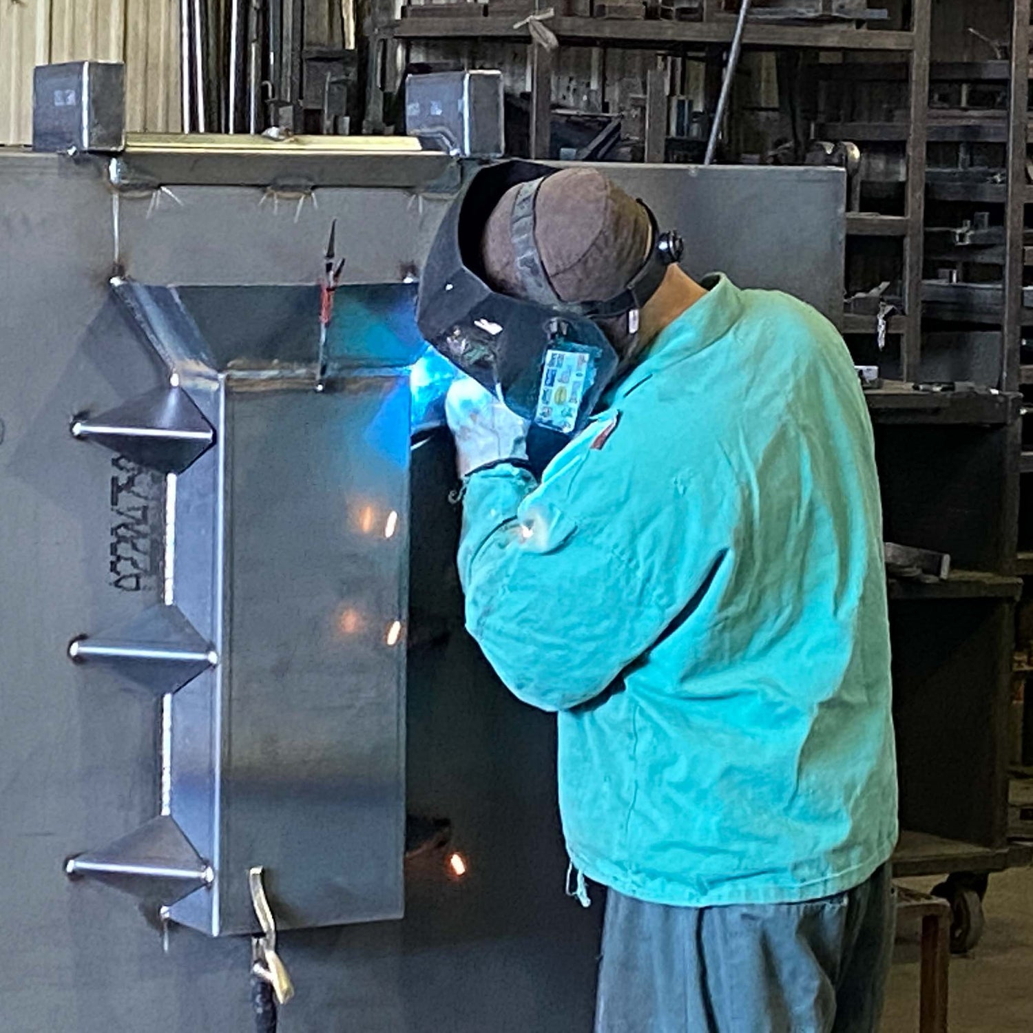 worker welding a metal dumpster